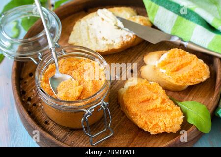 Snack oder Frühstück. Sandwiches mit Butter und gesalzenem Kaviar auf einem hölzernen Küchentisch. Stockfoto