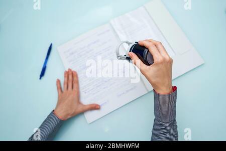 Kleines Mädchen setzt einen Stempel auf Dokumente Stockfoto