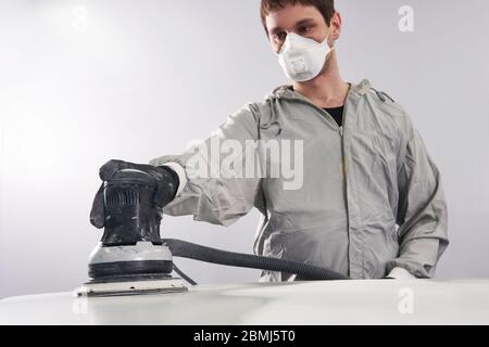 Auto Mechaniker tragen Gesichtsmaske Schwabbelung und Polieren Haube im Auto-Werkstatt Stockfoto