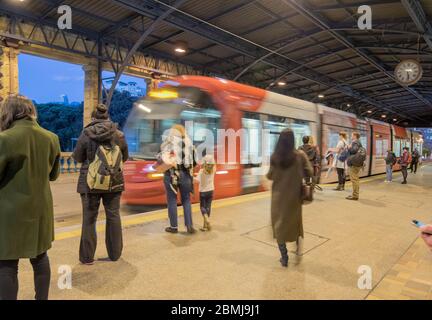 Pendler warten auf die Fahrt in eine nahende Straßenbahn am Hauptbahnhof während des abendlichen Pendelverkehrs im Winter in Sydney, Australien Stockfoto