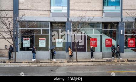 Einheimische aus Toronto üben soziale Distanz während sie in der Schlange vor dem Lebensmittelgeschäft während der Coronavirus-Pandemie am 02. Mai 2020 in Ontario, Kanada warten. Stockfoto