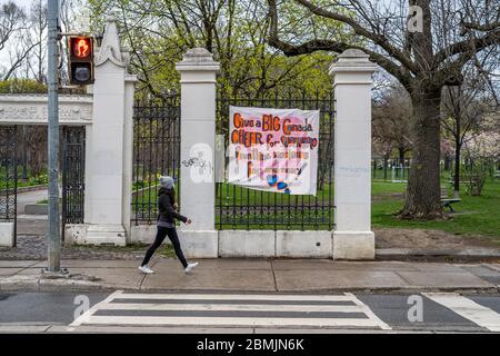 Toronto, Ontario, Kanada, eine einheimische Frau mit Gesichtsmaske geht durch bunte Banner, die die Arbeiter an vorderster Front während der Coronavirus-Pandemie loben. Stockfoto