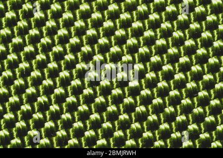 Synthetische Gewebe Textur Nahaufnahme. Grüne geflochtene Oberfläche. Gewebter Hintergrund. Nähte von Fasern Stockfoto