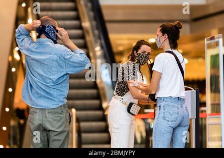 Berlin, Deutschland. Mai 2020. Kunden tragen Gesichtsmasken und desinfizieren ihre Hände, bevor sie in ein Geschäft in Berlin, Deutschland, am 9. Mai 2020, eintreten. Bundeskanzlerin Angela Merkel sagte am Mittwoch, dass die COVID-19-Beschränkungen in Deutschland gelockert werden, während die Mindestvorschriften für soziale Distanz und Hygiene weiterhin gelten. Kredit: Binh Truong/Xinhua/Alamy Live News Stockfoto