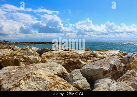 Ein Hafen aus Felsen. Welliges Meer und wolkiges windiges Wetter. Stockfoto