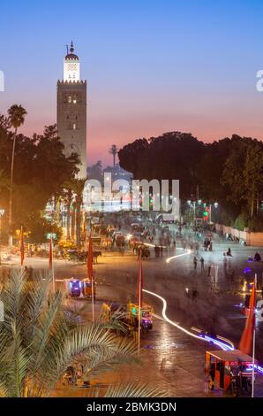 Das Minarett der Kasbah Moschee in den belebten Platz Jemaa el-Fnaa bei Sonnenuntergang von der Terrasse Marrakesh-Safi in Marrakesch, Marokko. Stockfoto