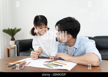 Ein Paar junger asiatischer Vater und Tochter zeichnen im Wohnzimmer Stockfoto