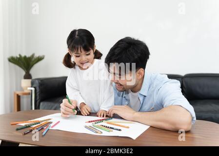 Ein Paar junger asiatischer Vater und Tochter zeichnen im Wohnzimmer Stockfoto