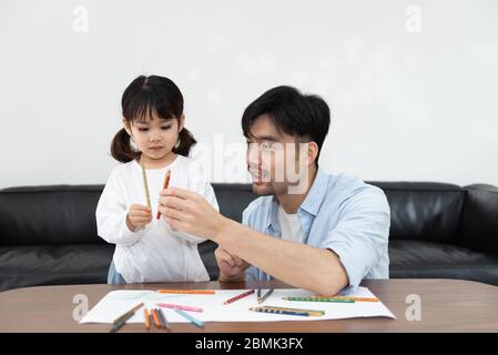 Ein Paar junger asiatischer Vater und Tochter zeichnen im Wohnzimmer Stockfoto