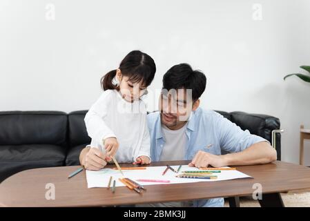 Ein Paar junger asiatischer Vater und Tochter zeichnen im Wohnzimmer Stockfoto