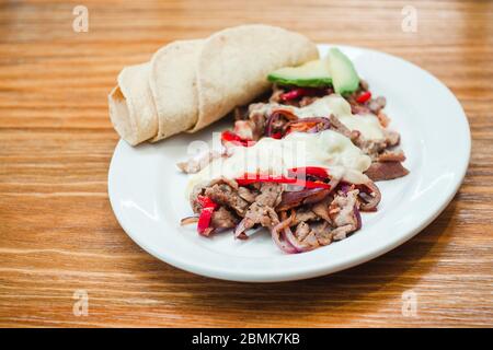 Mexikanische Küche, Alambre wird mit Rindfleisch, Zwiebeln, Speck, Chili, Käse und Tortillas in Mexiko Stockfoto