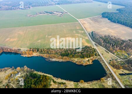 Malerische Frühlingslandschaft der Landschaft. Blauer See, grüne Felder und Wald am Horizont. Panorama-Luftaufnahme Stockfoto