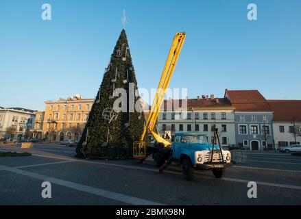 Ein LKW preps einen riesigen, gefälschten Weihnachtsbaum auf dem Altstädter Rotušė-Platz. In Vilnius, Litauen. Stockfoto