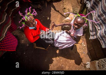 Nairobi, Kenia. Mai 2020. Die 12-jährige Martha Apisa (links) und ihre Nachbarin Stacy Ayuma (rechts) werden mit ihren Haarflechten beobachtet, um während der Pandemie Bewusstsein und Aufsehen über den Corona-Virus zu schaffen. Kenia hat 649 bestätigte Fälle, 207 wiedergewonnene und 30 Todesfälle durch die COVID 19-Krankheit verzeichnet. Quelle: SOPA Images Limited/Alamy Live News Stockfoto