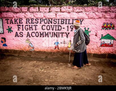 Nairobi, Kenia. Mai 2020. Eine Frau geht mit einem Graffiti an einer Wand vorbei, das Bewusstsein für covid 19 während der Corona-Virus-Pandemie schärft. Kenia hat 649 bestätigte Fälle, 207 wiedergewonnene und 30 Todesfälle durch die COVID 19-Krankheit verzeichnet. Quelle: SOPA Images Limited/Alamy Live News Stockfoto