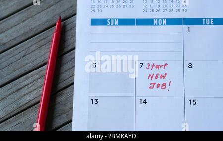 Neue Arbeitswörter in Tabellenkalender mit roter Markierung beginnen. Beschäftigung oder Karriere Konzept. Stockfoto