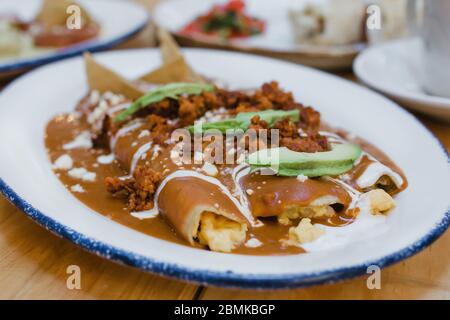 Enfrijoladas mexikanische Enchiladas mit Bohnen, traditionelle Küche der mexikanischen Gastronomie Stockfoto