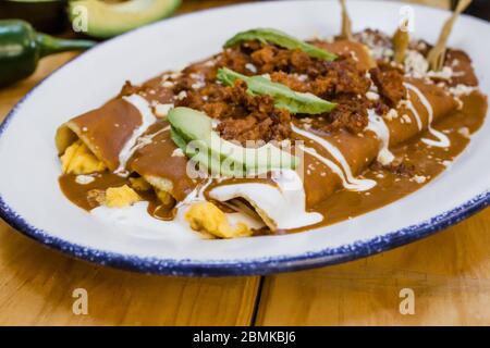 Enfrijoladas mexikanische Enchiladas mit Bohnen, traditionelle Küche der mexikanischen Gastronomie Stockfoto