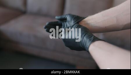 Mann Hände zieht aus schwarzen Nitril Schutzhandschuhe innen Stockfoto
