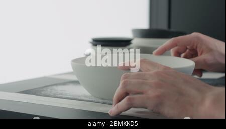 Mann Hände Sand Boden der weißen Keramikschale Stockfoto