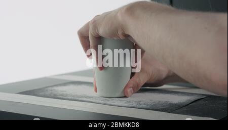 Mann Hände Sandboden aus weißem Keramikglas Stockfoto