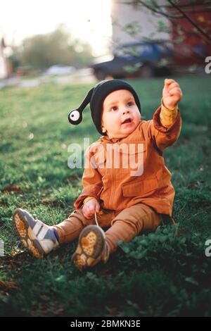 Porträt eines einjährigen Jungen mit einer Schneckenwollmütze auf dem Hintergrund der Natur Stockfoto