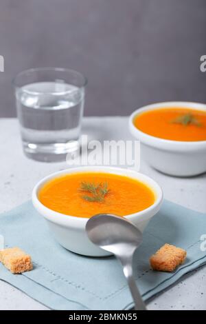 Hausgemachte gesunde Lebensmittel. Schüssel mit Kürbis und Karottencreme mit Croutons begleitet. Vegane Speisen. Freier Platz für Ihren Text. Vertikale Ausrichtung Stockfoto