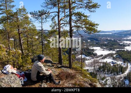 Ältere Paare, die sich auf einem Bergblick ausruhen und den Blick über die High Coast genießen, Bild von Mellansel Vasternorrland, Sverige. Stockfoto