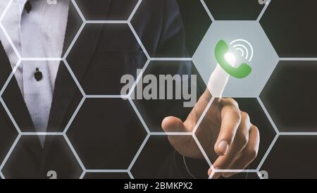 Kommunikation mit Mobiltelefonen. Collage mit Geschäftsmann drücken Anruf-Taste auf virtuellen Bildschirm mit sechseckigen Zellen Stockfoto