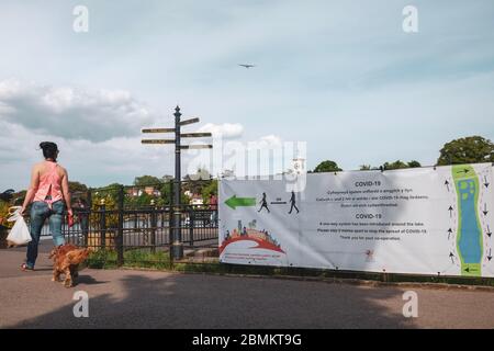 Roath, Cardiff. Covid-19 Zeichen illustrieren soziale Distanzierungsmaßnahmen in Roath Park, Cardiff. Stockfoto