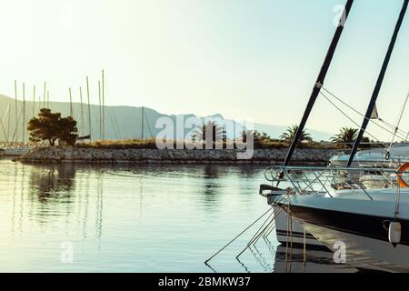Segelboote in einer Reihe in einem kleinen Hafen in Split, kroatien verankert. Klares, wunderschönes Meer bei Sonnenaufgang am frühen Morgen Stockfoto