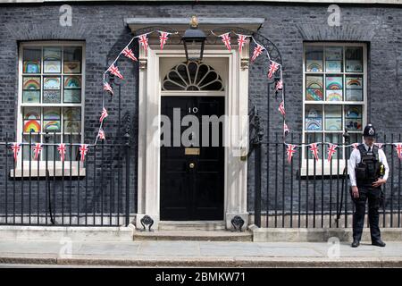 Ich habe Polizisten vor Nr. 10 in der Downing Street getroffen, die die zwei Minuten Stille um 11 Uhr am Tag des 75. Geburtstages in Whitehall, London, Großbritannien, beobachten Stockfoto