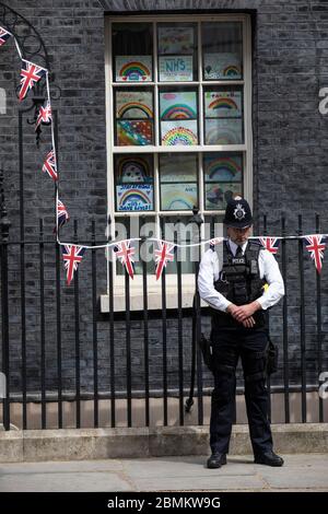 Ich habe Polizisten vor Nr. 10 in der Downing Street getroffen, die die zwei Minuten Stille um 11 Uhr am Tag des 75. Geburtstages in Whitehall, London, Großbritannien, beobachten Stockfoto