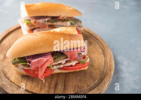 Sandwich Serranito typisch in Andalusien mit Schinken, gren Pfeffer und gegrilltem Schweinefleisch Lende Stockfoto