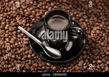 Espresso Kaffee in schwarzer Tasse und geröstete Bohnen. Kaffee Hintergrund Stockfoto