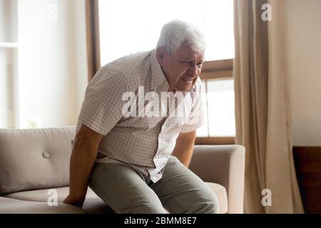 Ungesunder älterer Mann leidet zu Hause an Rheuma Stockfoto
