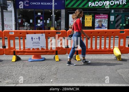 Die Menschen nutzen einen neuen, erweiterten Bürgersteig, um die soziale Distanz auf der Camden High Street in London zu fördern, da Großbritannien weiterhin in der Blockierung ist, um die Ausbreitung des Coronavirus einzudämmen. Stockfoto
