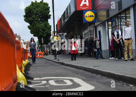 Die Menschen nutzen einen neuen, erweiterten Bürgersteig, um die soziale Distanz auf der Camden High Street in London zu fördern, da Großbritannien weiterhin in der Blockierung ist, um die Ausbreitung des Coronavirus einzudämmen. Stockfoto