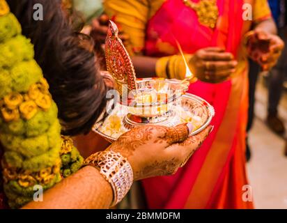 Eine Braut, die eine silberne Lampe als Ritual während einer südindischen Hindu-Hochzeit hält Stockfoto