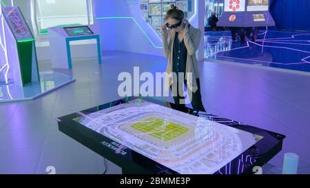 MOSKAU, RUSSLAND - 30. Juli 2018: Smart City Exhibition. Augmented Reality Experience: Frau mit speziellen Brillen und Blick auf Display-Tisch mit Stockfoto