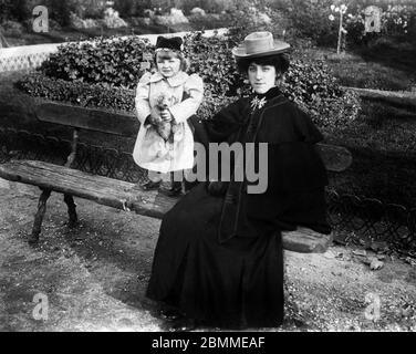 Belle epoque : Portrait d'une elegante jeune femme, vetue d'un manteau a Cape et d'un chapeau, et sa petite fille, Pächter son ours en peluche, dans un Stockfoto