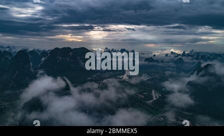 Luftaufnahme der Wolkenlandschaft über Ackerland, Fluss und Hügelwäldchen Stockfoto