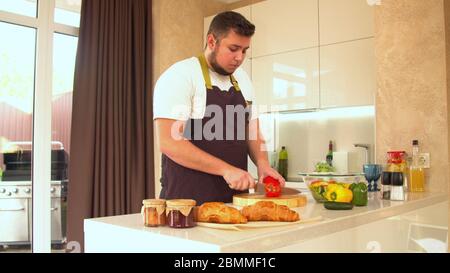 Medium Schuss eines Mannes schneiden gelbe Paprika für Salat Stockfoto