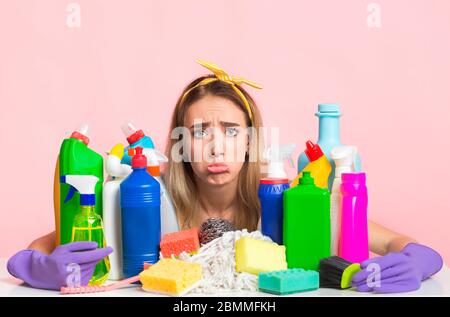 Arsenal Reinigungszubehör für Hausreinigung Konzept. Traurig lustig Hausfrau Umarmungen Flasche, Schwamm und Spray Stockfoto