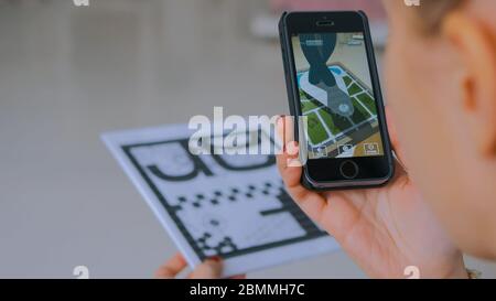 MOSKAU, RUSSLAND - 29. AUGUST 2018. Frau mit Smartphone mit Augmented Reality App und Platzierung virtuellen Modell des modernen Gebäudes im Raum. Zukunft Stockfoto