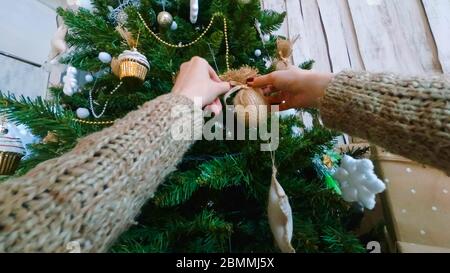 Frau schmücken weihnachtsbaum mit Spielzeug. Blickpunkt aufgenommen. Ferien, Feier und weihnachtskonzept Stockfoto