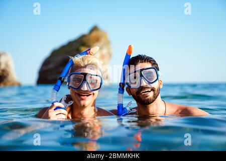 Glückliche Freunde Männer genießen Sommerurlaub und Tauchen Stockfoto