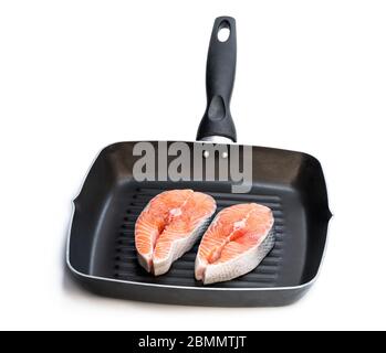 Frisches Lachssteak in einer Grillpfanne, isoliert auf Weiß. Bereit zum Kochen Stockfoto