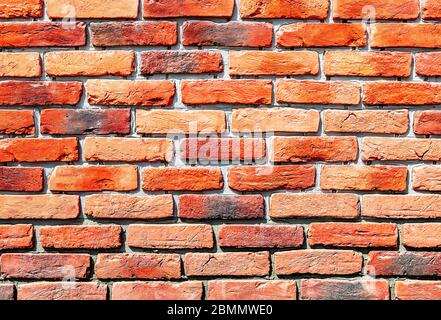 Alte verwitterte rote Ziegelwand als Hintergrund. Ziegelmauerwerk mit Nähten Stockfoto