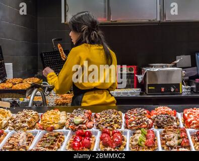 Frau bereitete Belgien Waffel auf Weihnachtsmarkt in Brüssel, Belgien am 30. Dezember 2019. Stockfoto